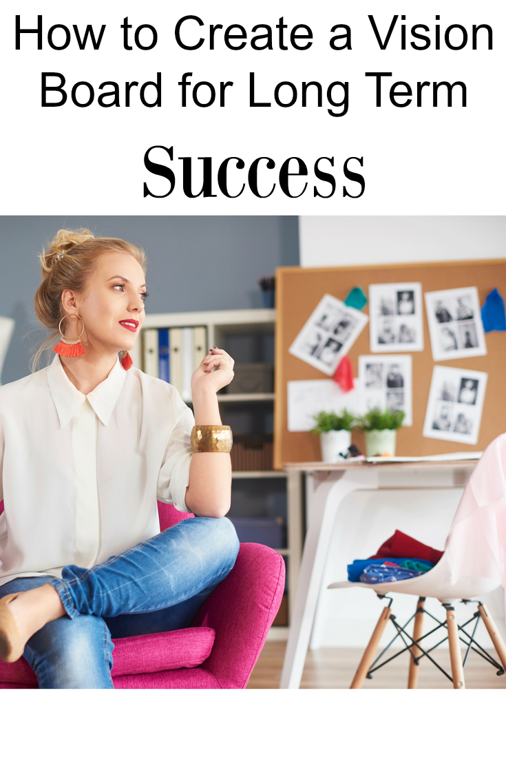 A girl sitting in a comfy chair with a vision board in the background